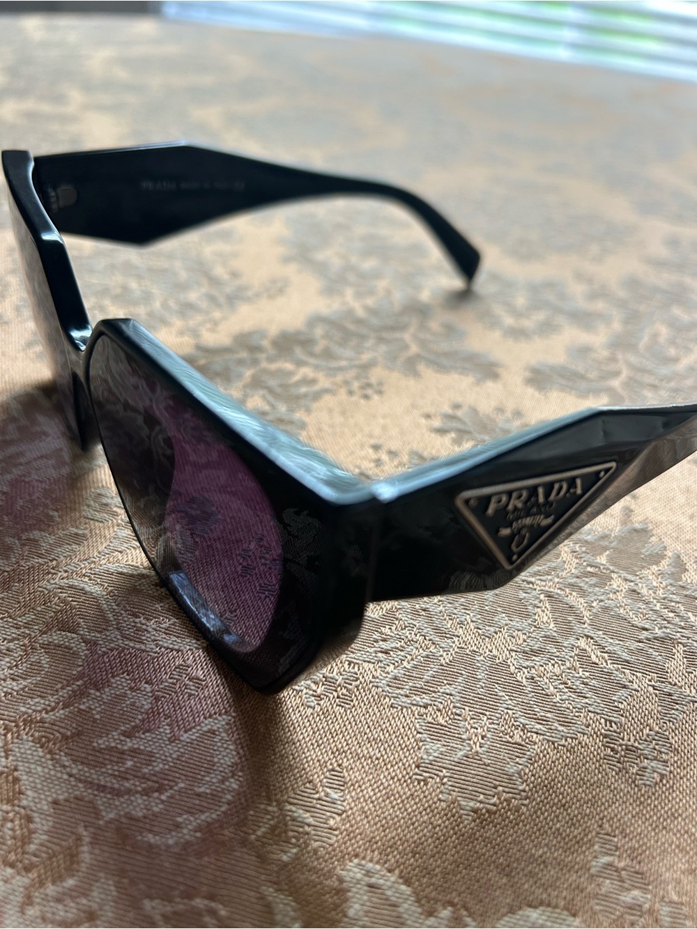 Prada Black Frame Sunglasses with Dark Purple Lenses.